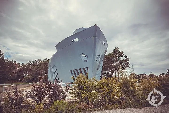 A large, light-blue building designed to look like the bow of a ship