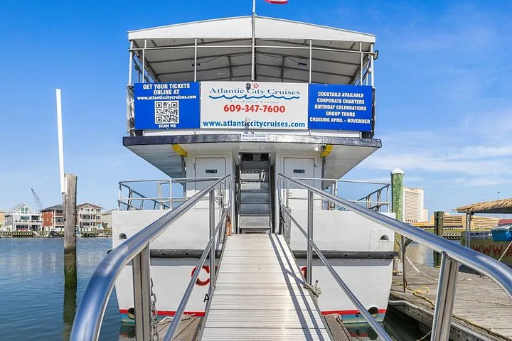 Rear view of a tour boat docked with a boarding ramp leading to it
