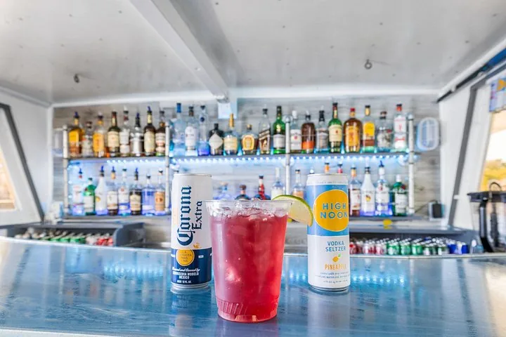 Un bar su una barca con un drink rosso, Corona e seltz High Noon