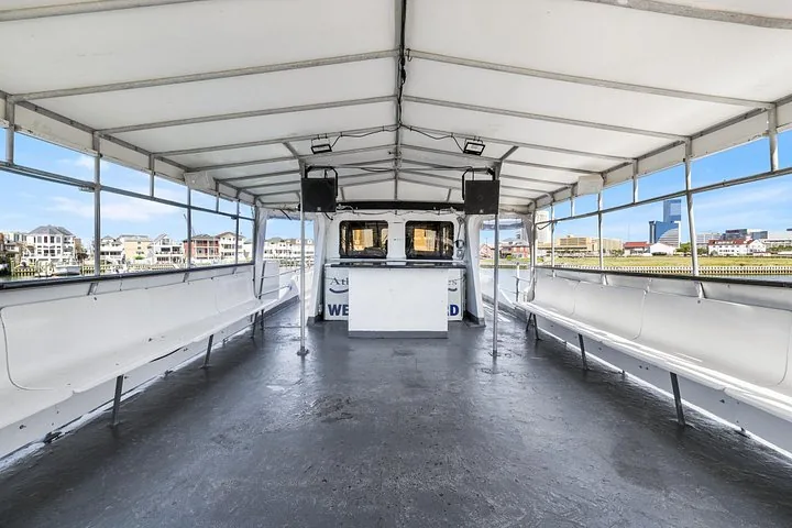 Ponte superiore di una barca per tour guardando in avanti verso una piccola console bar bianca